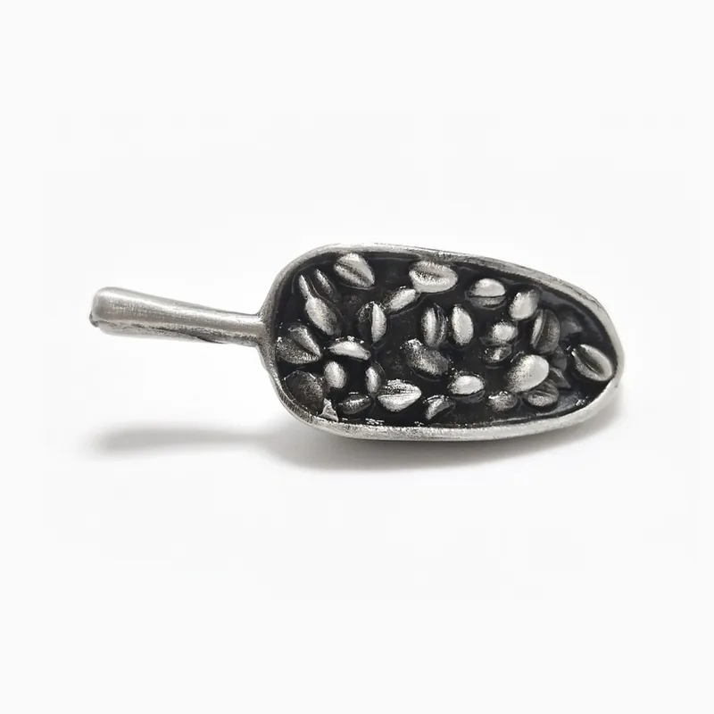 Pin 3D plateado fundido con forma de cuchara rebosante de granos de café tostado