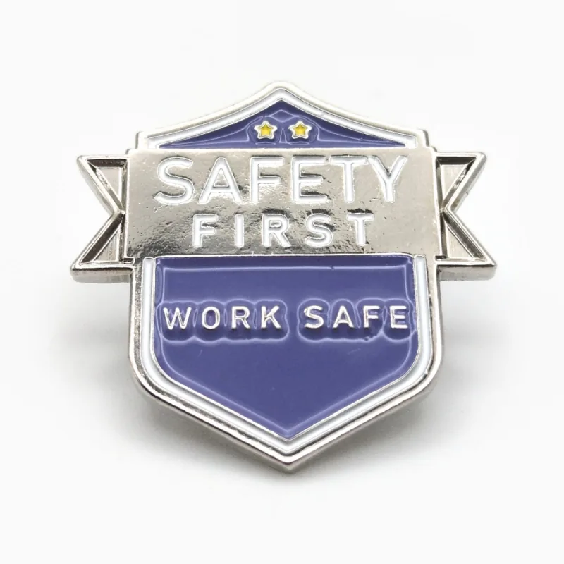 Pin de esmalte suave en forma de escudo con baño de níquel, una banda plateada «Safety First» y un escudo morado «Work Safe».