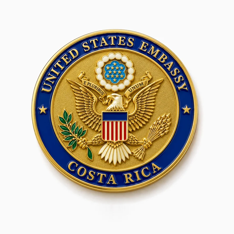 Pin redondo dorado con anillo de esmalte azul que dice United States Embassy Costa Rica y el escudo del águila