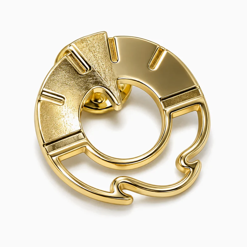 Pin troquelado dorado de un aro abierto con muescas, una cuña con textura y una base calada ondulada