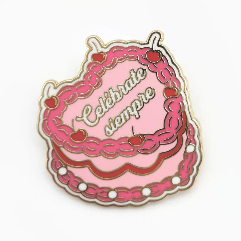 Pin de esmalte duro de un pastel rosa en forma de corazón con betún blanco y letras cursivas