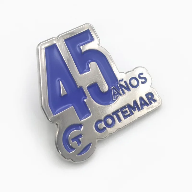 Pin de esmalte plateado y azul que dice “45 años”, hecho para el aniversario de una empresa de servicios energéticos.