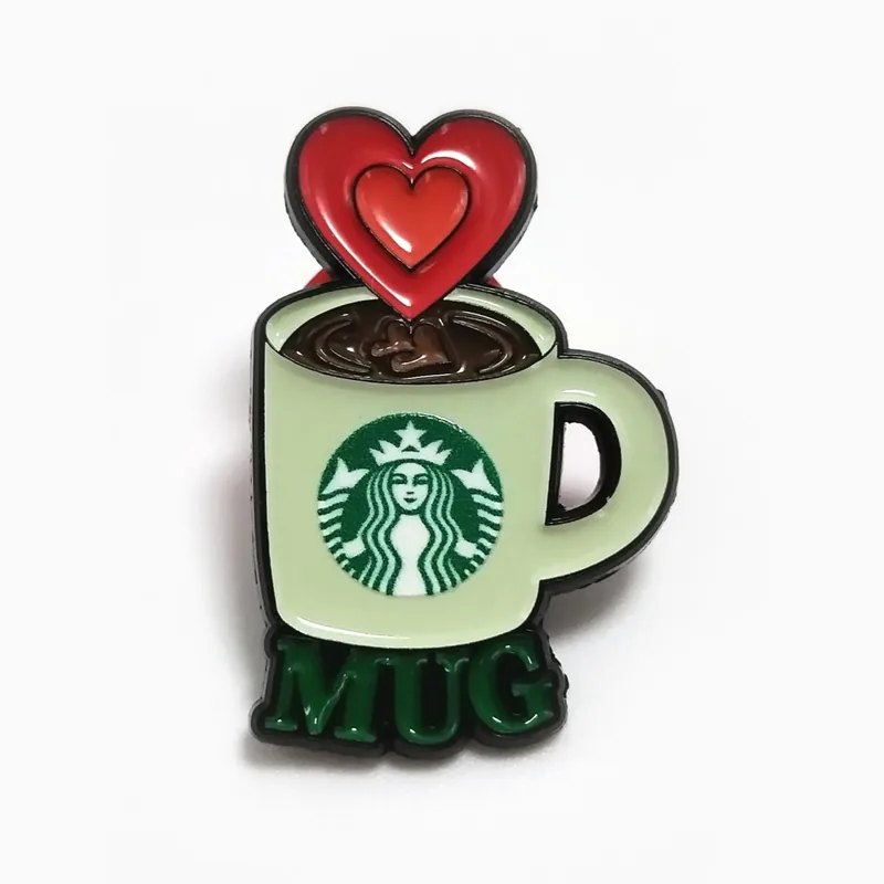 Pin de esmalte de una taza de café verde de la que sale un corazón rojo, hecho para una cadena de cafeterías.