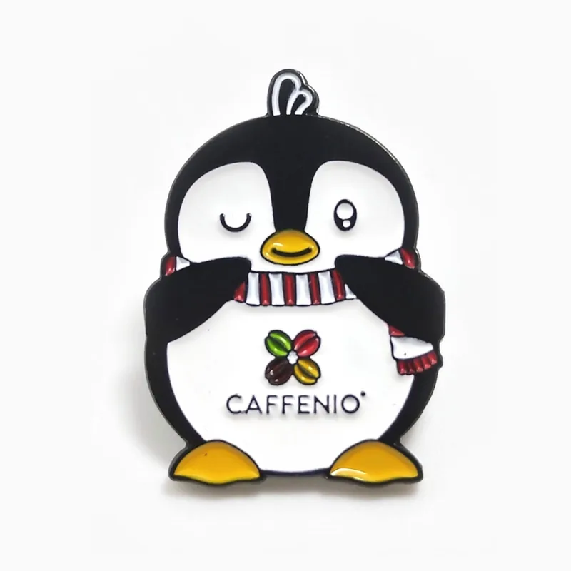 Pin de esmalte de una mascota pingüino con bufanda, hecho para una cadena de cafeterías.