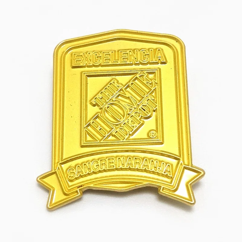 Pin insignia troquelado en dorado pulido con letras en relieve, hecho para una cadena de artículos para el hogar y construcción.