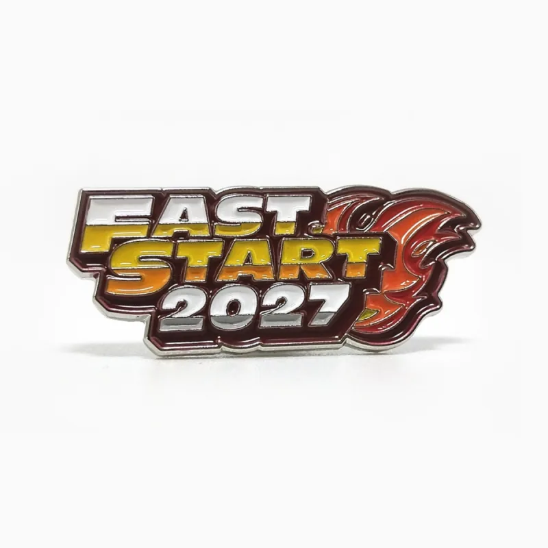 Pin troquelado de esmalte suave con baño de níquel y el texto «Fast Start 2027» en rojo, naranja y dorado, con una estela de fuego.