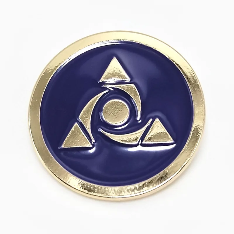 Pin redondo de esmalte suave con baño dorado y un emblema dorado de triángulo y círculo en relieve sobre esmalte azul marino.