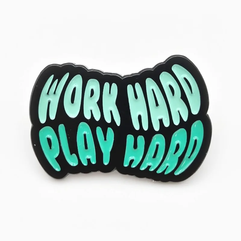 Pin troquelado de esmalte suave con baño de níquel negro y el texto ondulado «Work Hard Play Hard» en verde menta.