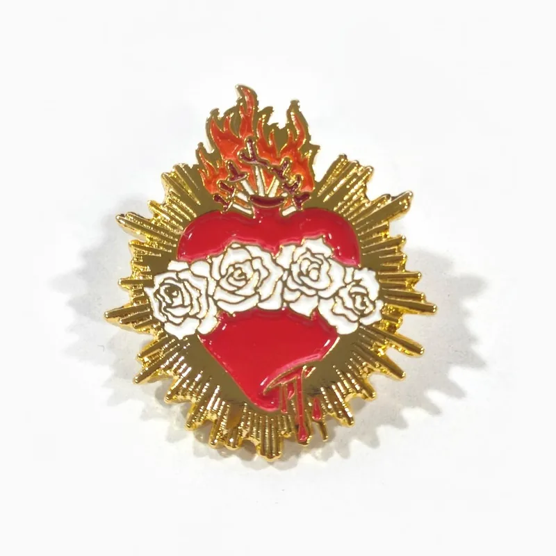 Pin dorado de esmalte suave de un sagrado corazón con esmalte rojo, rosas blancas y rayos de llamas dorados