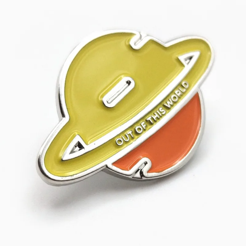 Pin troquelado de esmalte suave de un planeta amarillo y naranja con anillo y el texto «Out of this world».