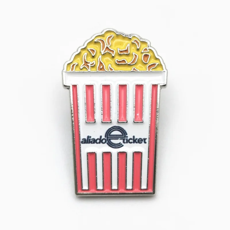 Pin troquelado de esmalte suave de una caja de palomitas a rayas rojas y blancas llena de palomitas amarillas, con un pequeño logotipo en la caja.