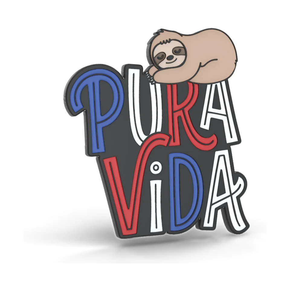 Imán de PVC suave con letras PURA VIDA en rojo, blanco y azul y un perezoso dormido encima.