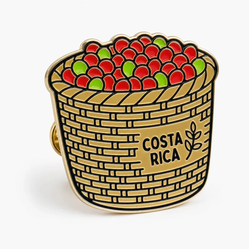 Pin de esmalte suave de un canasto tejido para recoger café lleno de granos rojos y verdes, con el texto Costa Rica.